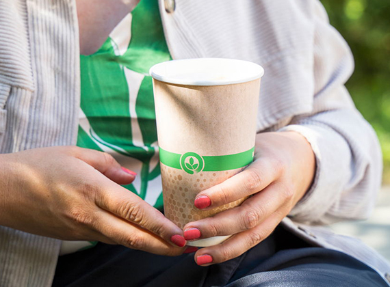 Woman holding a sustainable disposable coffee cup